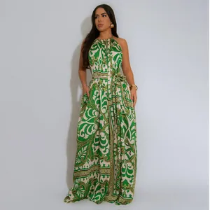Ganzkörperansicht einer Frau in einem grün-cremefarbenen bedruckten rückenfreien Jumpsuit.