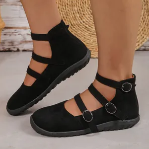 Close-up view of vintage black suede Mary Jane flats with triple buckled straps