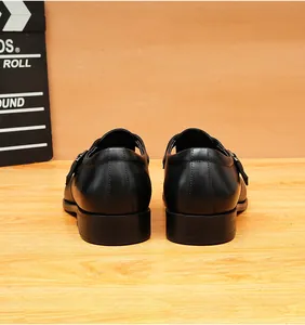 Rear view of black genuine leather monk strap sandals with buckle detail.