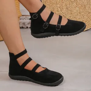 Close-up of vintage black suede Mary Jane shoes featuring unique triple buckle straps