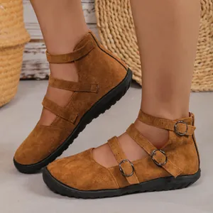 Close-up of vintage brown suede Mary Jane shoes featuring three buckled straps.