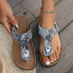 Detailansicht Damen-Flip-Flops mit Wellenmuster, Korkfußbett und verstellbarer Schnalle.