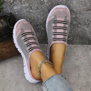 Detailed close-up view of pink and grey flying knit slip-on mules with a thick white sole