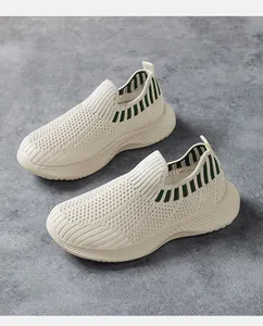 Λεπτομέρεια από αναπνεύσιμα παιδικά slip-on αθλητικά σε μπεζ με πράσινες λεπτομέρειες