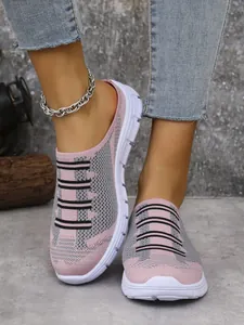 Close-up of women's breathable pink and grey knit slip-on mules on foot