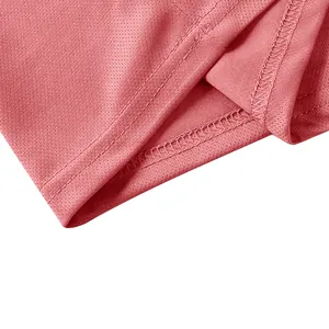 Macro detail view showing the breathable mesh texture and neat stitching of the pink polo shirt.