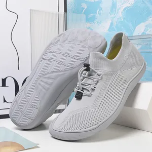 Dettaglio scarpe barefoot grigie con suola sagomata e sistema di allacciatura rapida