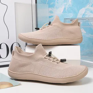 Dettaglio scarpe a piedi nudi in maglia traspirante con sistema di allacciatura rapida.