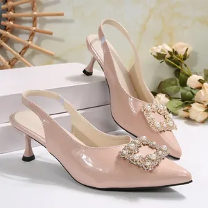 Detailed view of nude pointed-toe slingback heels with elegant pearl square buckle