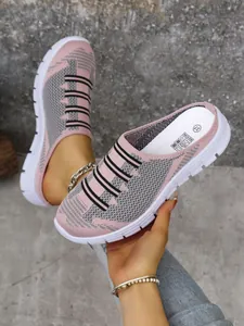 Close-up of pink fly-knit breathable slip-on mules with black stripes