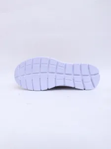 Detailed view of the anti-slip textured outsole of a white women's slip-on mule sneaker