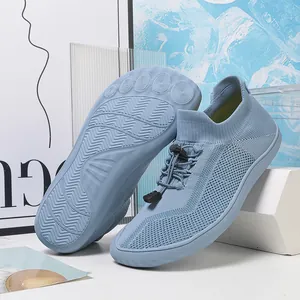 Dettaglio scarpe a piedi nudi azzurre con tomaia in maglia e suola in gomma antiscivolo