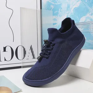 Dettaglio di scarpa da camminata in maglia blu scuro con sistema di lacci regolabili.
