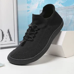 Vista dettagliata delle sneakers outdoor in maglia nera traspirante con lacci elastici
