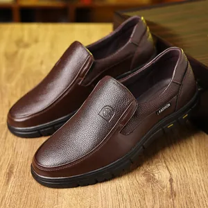 Detail von braunen Herren-Slippern aus echtem Leder mit genarbter Textur und FASHION-Label