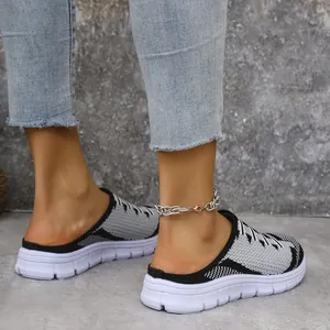Detailed side view of women's grey fly-knit slip-on mules featuring white thick soles