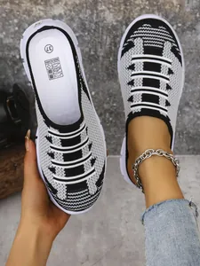 Detail view of breathable black and white fly-knit mesh slip-on mules for women