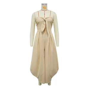 Detail of beige strapless jumpsuit showing front tie-knot and draped wide-leg pants