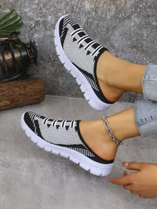 Detail shot of black and white fly-woven mesh mules featuring stylish geometric patterns