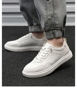 Close-up of white suede men's casual sneakers with leather panels on asphalt ground.