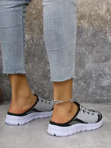 Detail side view of breathable knit mules for women featuring thick white sport soles.