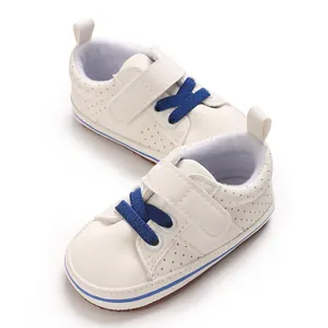 Detailed view of white newborn baby walking shoes with blue laces and velcro straps