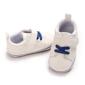 High-quality close-up of white baby walker shoes featuring blue laces and flexible soft soles.