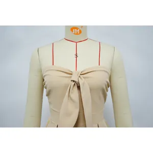 Close-up of beige strapless jumpsuit with decorative front knot detail