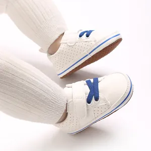 Close-up of white baby walking shoes with blue laces and soft anti-slip soles