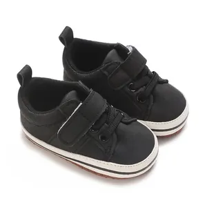 Close-up of black baby sneakers with soft soles and velcro straps for toddler boys