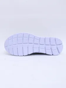 Detailed bottom view of white slip-on mule outsole with non-slip tread patterns