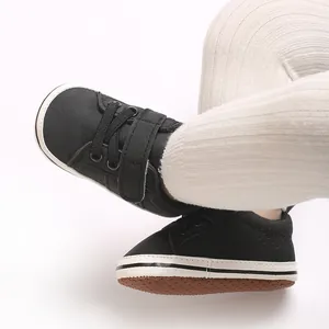 Close-up of black infant pre-walker shoes with velcro strap on white background