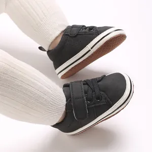 Detail view of black infant walking shoes featuring soft soles and velcro straps