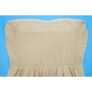 Close-up detail of the elastic smocked bodice on a sexy beige strapless summer jumpsuit