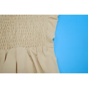 Detailed view of beige smocked bodice texture on women's solid color summer jumpsuit