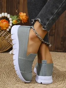 Detailansicht von atmungsaktiven grauen Mesh-Slippern mit robuster weißer Sohle.