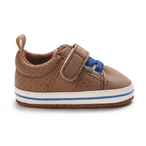 Detail view of brown baby walking shoe with perforations and blue elastic laces