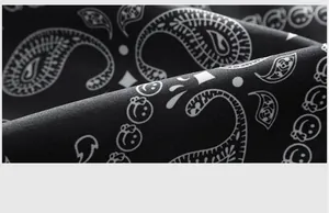 Vista macro dettagliata del tessuto dei pantaloncini da mare neri con stampe paisley e smiley