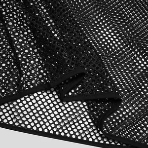 Close-up detail of black breathable fishnet mesh fabric on men's see-through T-shirt