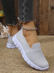 Detailansicht grauer atmungsaktiver Mesh-Slipper mit bequemen weißen Plateausohlen für Damen.