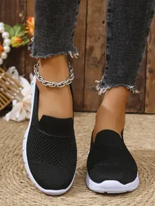Nahaufnahme der schwarzen atmungsaktiven Mesh-Slipper mit weißen Sohlen für Damen