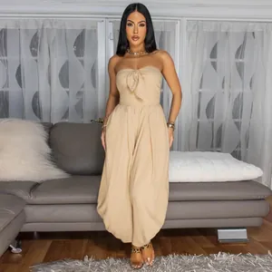 Full view of elegant beige strapless jumpsuit with front bow detail on model