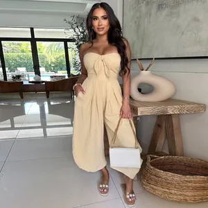 Sexy strapless knot-front jumpsuit in beige displayed on a model in a modern interior.