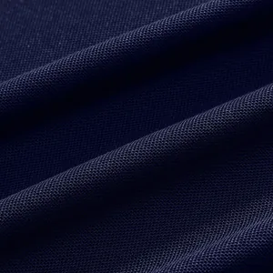 Close-up macro view of breathable navy blue pique fabric for summer golf polo shirts.