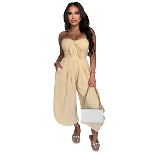 Front view of an elegant beige strapless jumpsuit featuring a front bow tie design