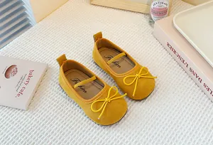 Close-up of yellow suede Mary Jane shoes for girls with cute bow detail