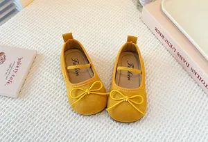 Detailed view of yellow girls' Mary Jane shoes with elegant bow decoration