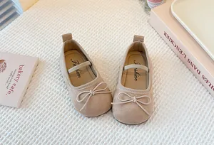 Beige children's Mary Jane flats featuring a soft bow and suede-like texture