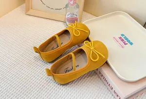 Close-up of yellow children's Mary Jane shoes with delicate bow and soft texture