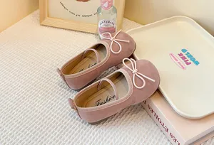 Detailed view of pink suede children's Mary Jane shoes with elegant bow decoration.